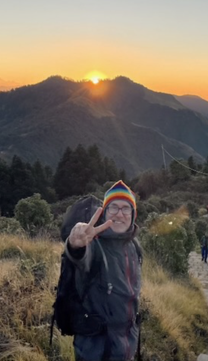 RobbieDob giving a peace sign on a mountain trail at sunrise